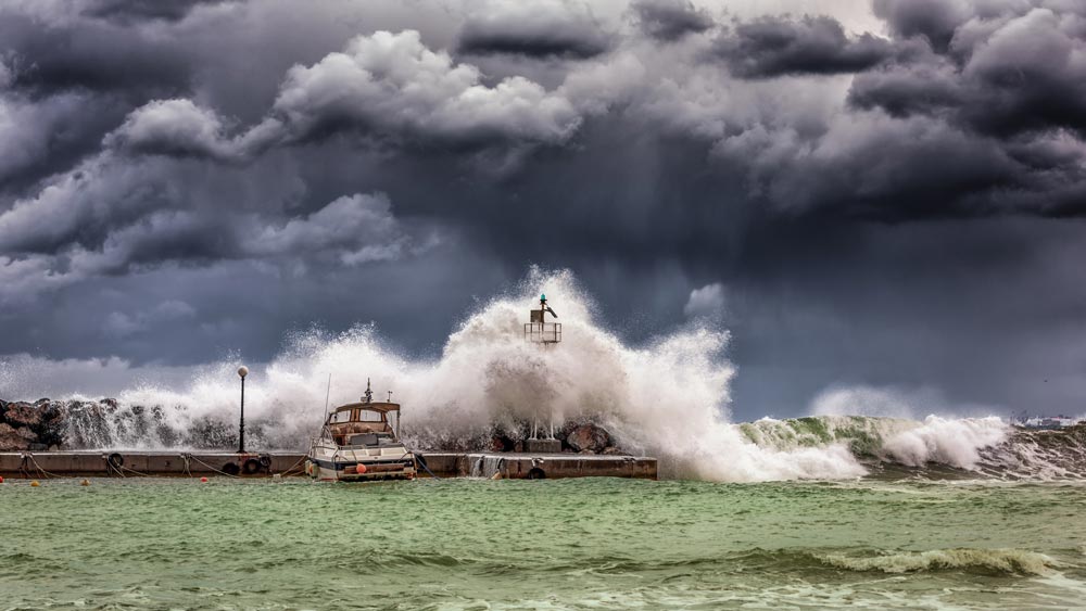 Wave crashing against a harbour in stormy weather